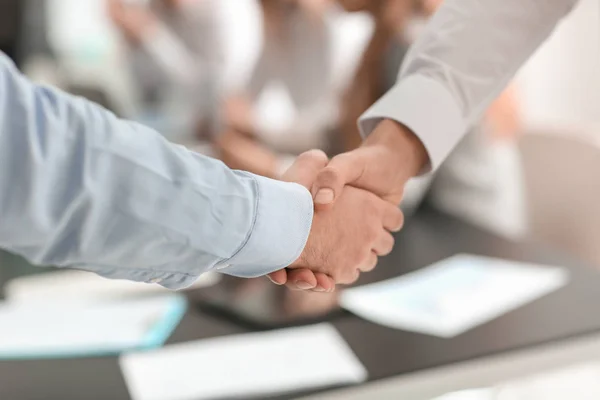 Two young men shaking hands at business meeting — Stock Photo, Image
