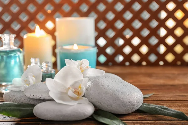 Pierres de spa avec de belles fleurs sur table en bois — Photo