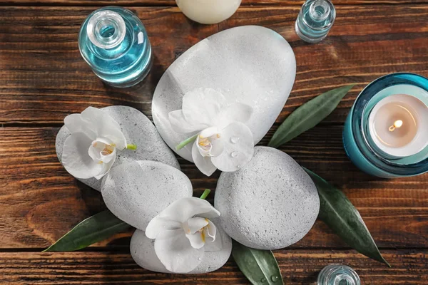 Wellness-Steine mit schönen Blumen auf Holztisch — Stockfoto