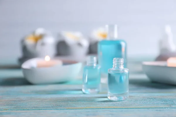 Bottle of essential oil for spa procedures on wooden table — Stock Photo, Image