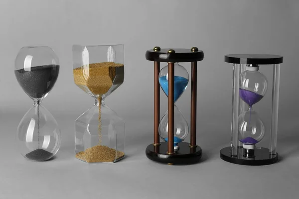 Hourglasses on grey background. Time management concept — Stock Photo, Image