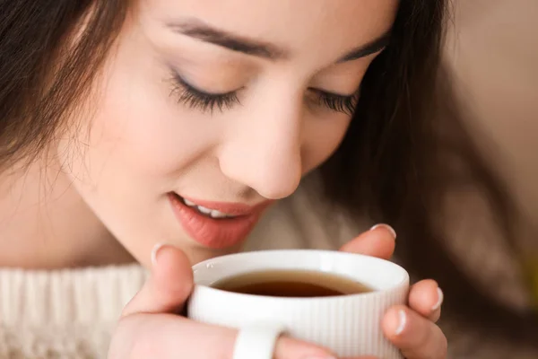 Hermosa joven con taza de té caliente en casa, primer plano — Foto de Stock