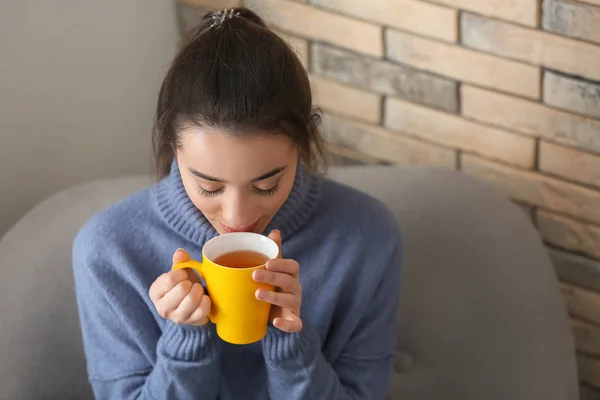 Beautiful young woman with cup of hot tea at home — Stock Photo, Image