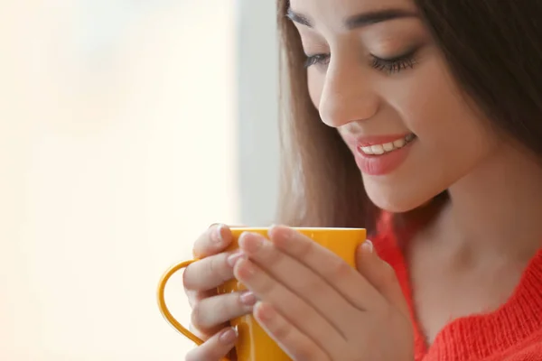 美丽的年轻女子与杯热茶在家里, 特写 — 图库照片