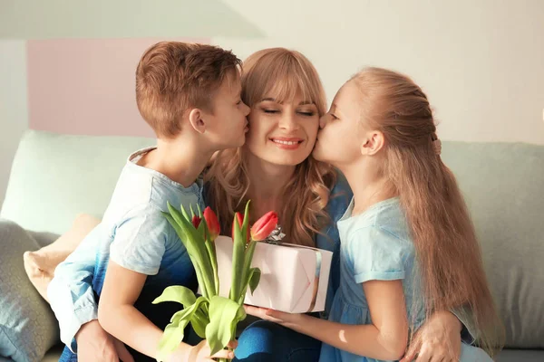 Schattige kleine kinderen feliciteren met hun moeder thuis — Stockfoto