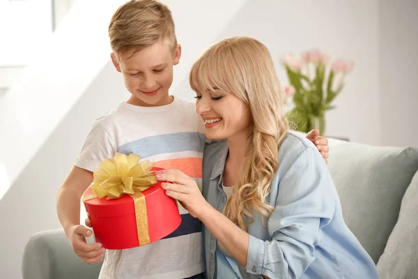 Portrait of cute little boy and his mother with gift box at home — Stock Photo, Image