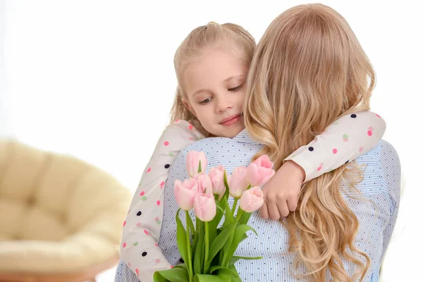 Retrato de linda niña y su madre con ramo de tulipanes en casa — Foto de Stock