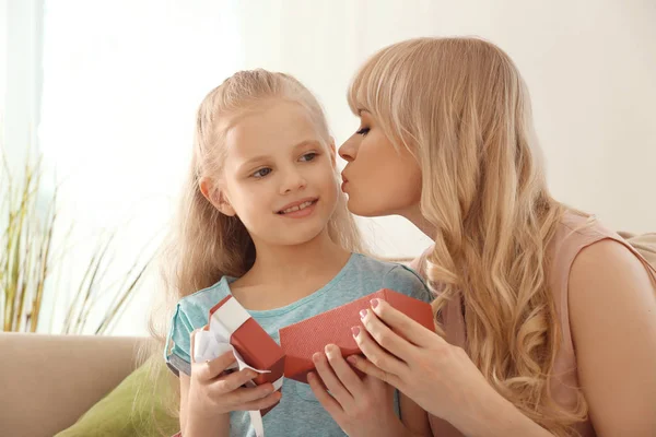 Young woman opening gift from her daughter at home. Mother's day celebration — Stock Photo, Image