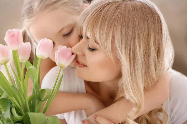 Portrait of cute little girl and her mother with tulip bouquet at home — Stock Photo, Image