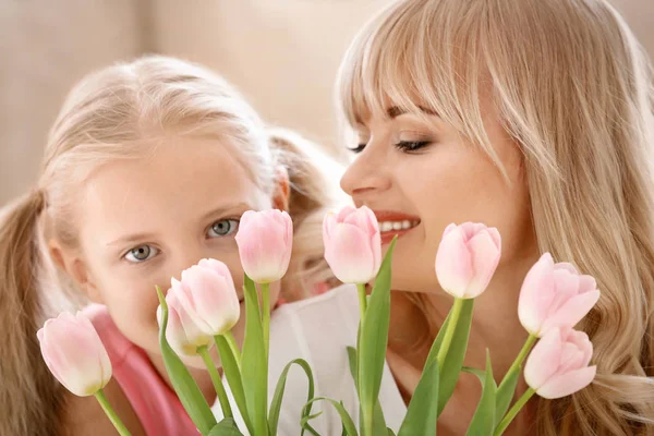 可爱的小女孩和她的母亲的肖像在家里的郁金香花束 — 图库照片