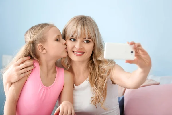 Cute little girl and her mother taking selfie at home — Stock Photo, Image