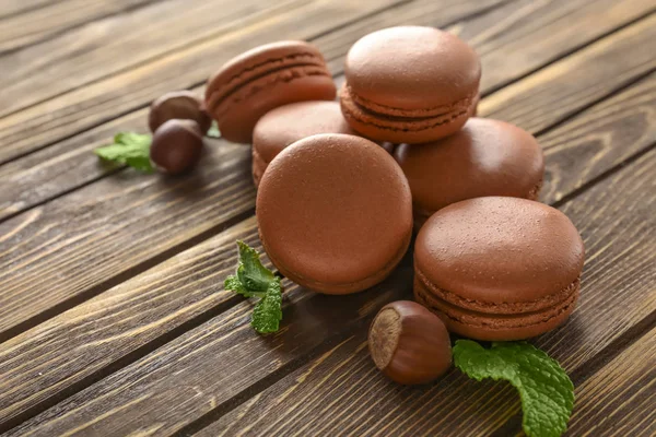 Tasty chocolate macarons on wooden background — Stock Photo, Image