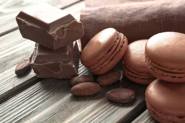 Tasty chocolate macarons on wooden background — Stock Photo, Image