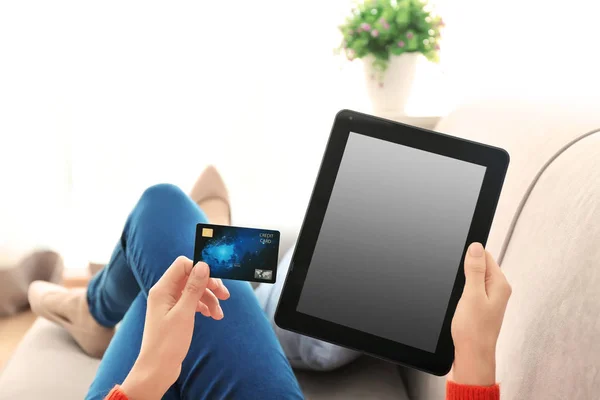 Young woman with credit card using tablet computer at home — Stock Photo, Image