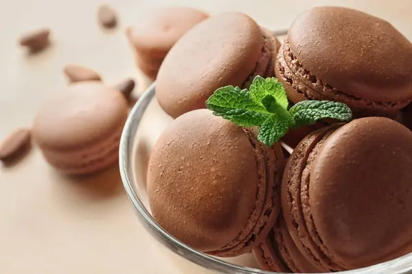 Bowl with delicious chocolate macarons on table — Stock Photo, Image