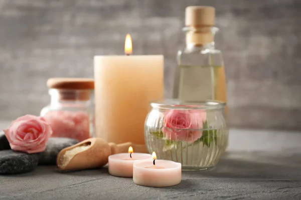 Spa composition with candles and flowers on grey table — Stock Photo, Image