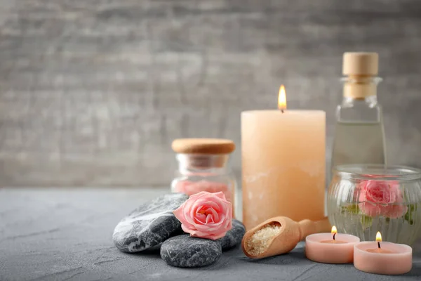 Composición spa con velas y flores sobre mesa gris —  Fotos de Stock