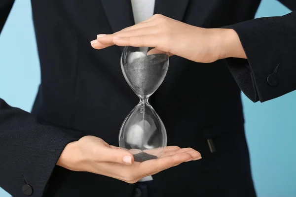 Woman holding hourglass, closeup. Time management concept