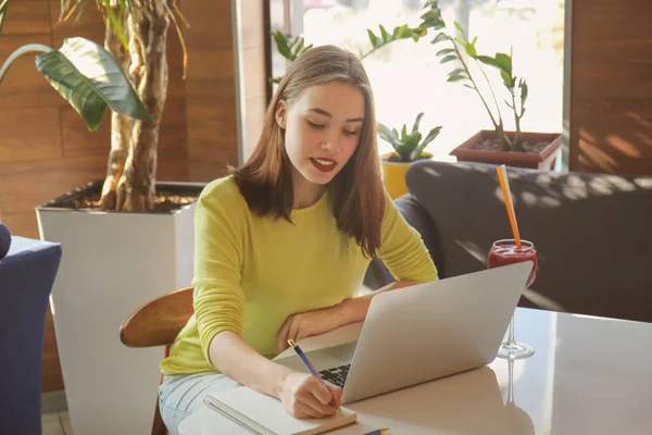 Freelancer jovem trabalhando com laptop no café — Fotografia de Stock