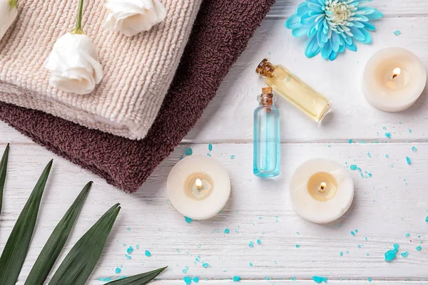 Vackra spa sammansättning med kosmetiska produkter, blommor och ljus på trä bakgrund, ovanifrån — Stockfoto