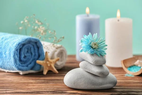 Mooie wellness samenstelling met stenen en bloem op houten tafel — Stockfoto