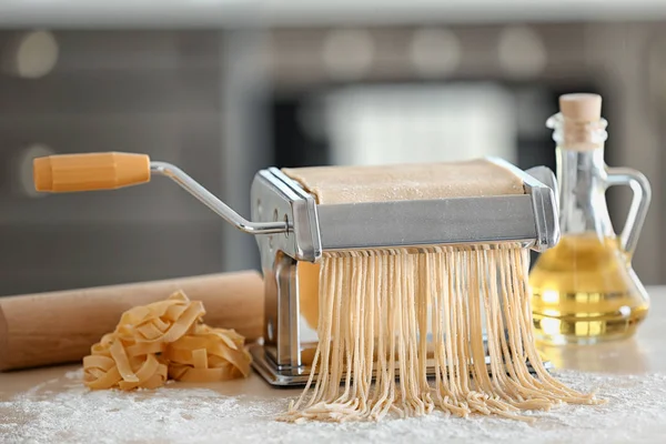 Pasta maker and products on kitchen table — Stock Photo, Image