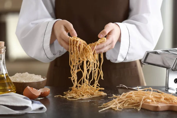 Vrouwelijke chef-kok pasta aan tafel bereiden — Stockfoto