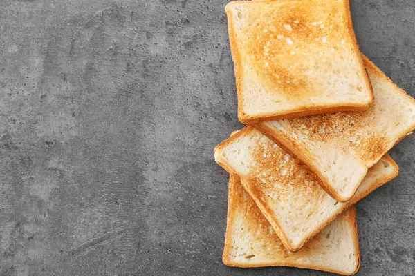 Välsmakande rostat bröd på grå bakgrund — Stockfoto