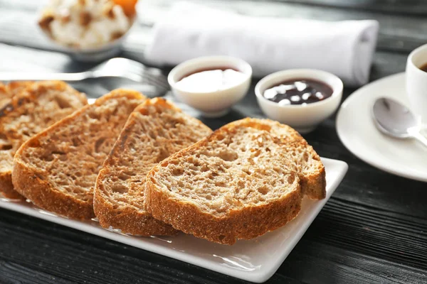 테이블에 맛 있는 구운된 빵과 접시 — 스톡 사진