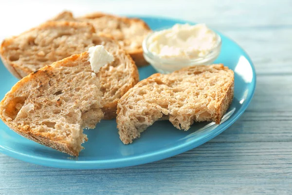 Plate with tasty toasted bread and cream cheese on table — Stock Photo, Image