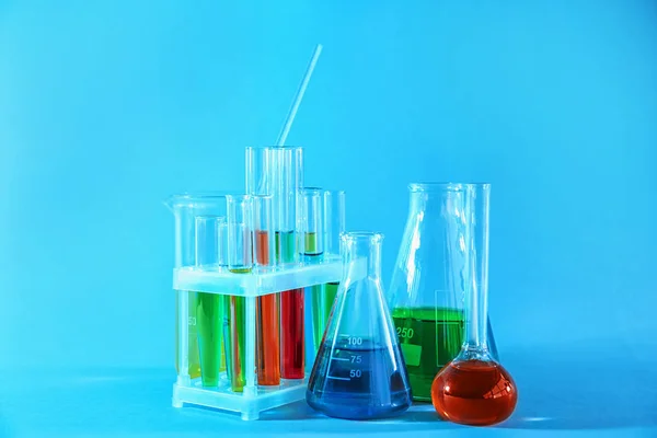 Vetreria chimica con campioni colorati su sfondo colore — Foto Stock
