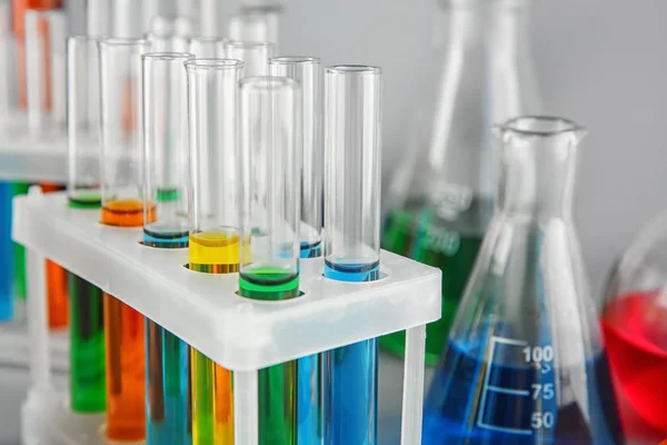 Test tubes with colorful liquids in holder, closeup — Stock Photo, Image