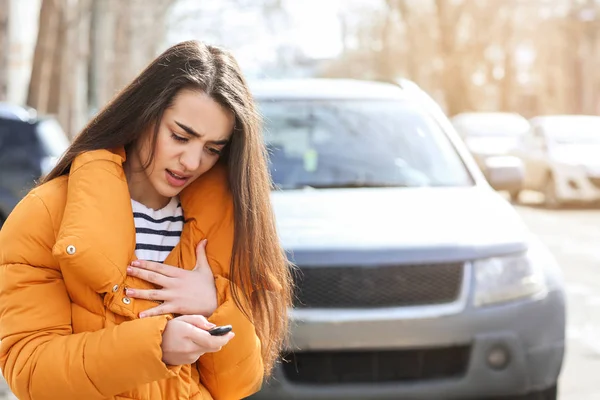 Mladá žena pomocí autoalarmu venku — Stock fotografie