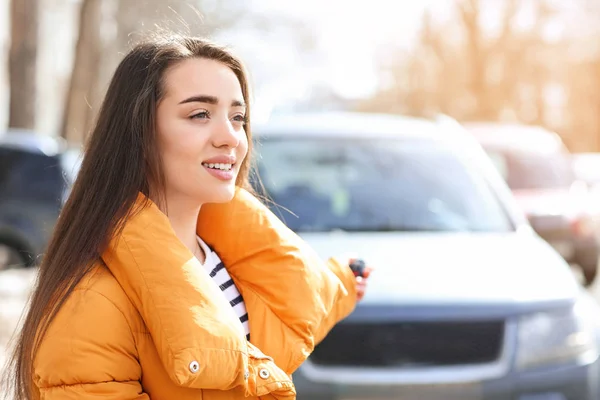 Young woman using car alarm outdoors — Stock Photo, Image