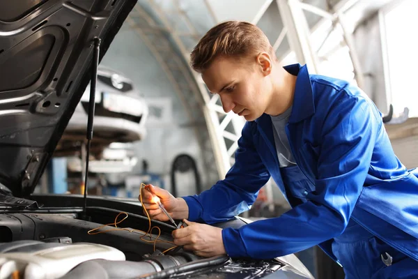 Mecánico masculino examinando coche en el centro de servicio — Foto de Stock
