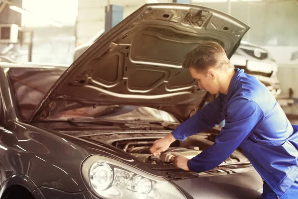 Mecánico masculino que fija el coche en el centro de servicio — Foto de Stock