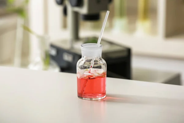 Flask con petali sul tavolo in laboratorio — Foto Stock