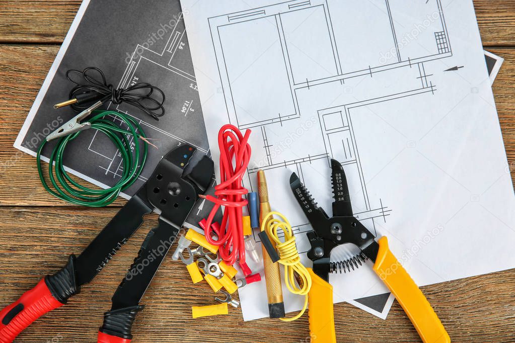 Flat lay composition with electrical tools and house plans on wooden background