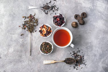 Kuru çay ve gri arka plan üzerinde lezzetli içecek farklı ile düz yatıyordu kompozisyon