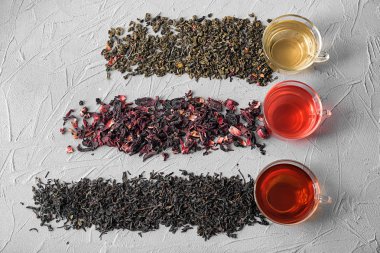 Kuru çay ve kupa gri arka plan üzerinde farklı tipleri ile düz yatıyordu kompozisyon