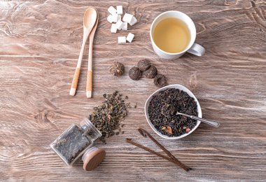 Kuru çay ve lezzetli içecek ahşap arka plan üzerinde farklı ile düz yatıyordu kompozisyon