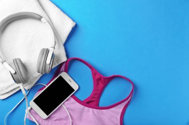 Spor top, smartphone, kulaklık ve havlu renk arka plan üzerinde düz yatıyordu kompozisyonu. Jimnastik salonu iş