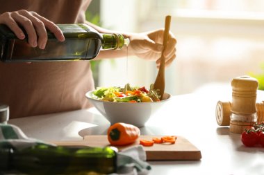 Tablo taze sebze salata bir kase içine zeytinyağı ekleyerek kadın