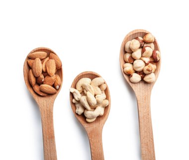 Beyaz arka plan üzerinde farklı fındık ile kaşık