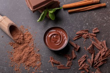 Gri zemin üzerine lezzetli eritilmiş çikolata ile kompozisyon