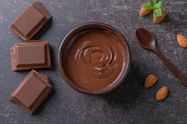 Gri zemin üzerine lezzetli eritilmiş çikolata ile kompozisyon