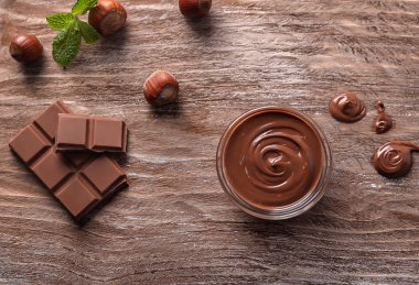 Ahşap arka plan lezzetli katı ve eritilmiş çikolata ile kompozisyon