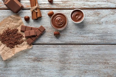 Ahşap arka plan lezzetli katı ve eritilmiş çikolata ile kompozisyon