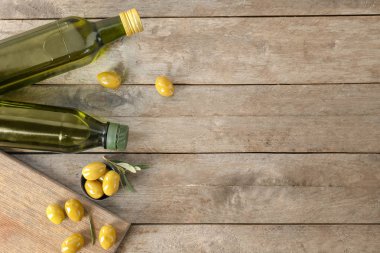 Şişe petrol ve ahşap zemin üzerine taze zeytin ile
