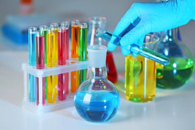 Şişeyi masada, closeup içine tüp sıvı dökme laboratuar işçisi